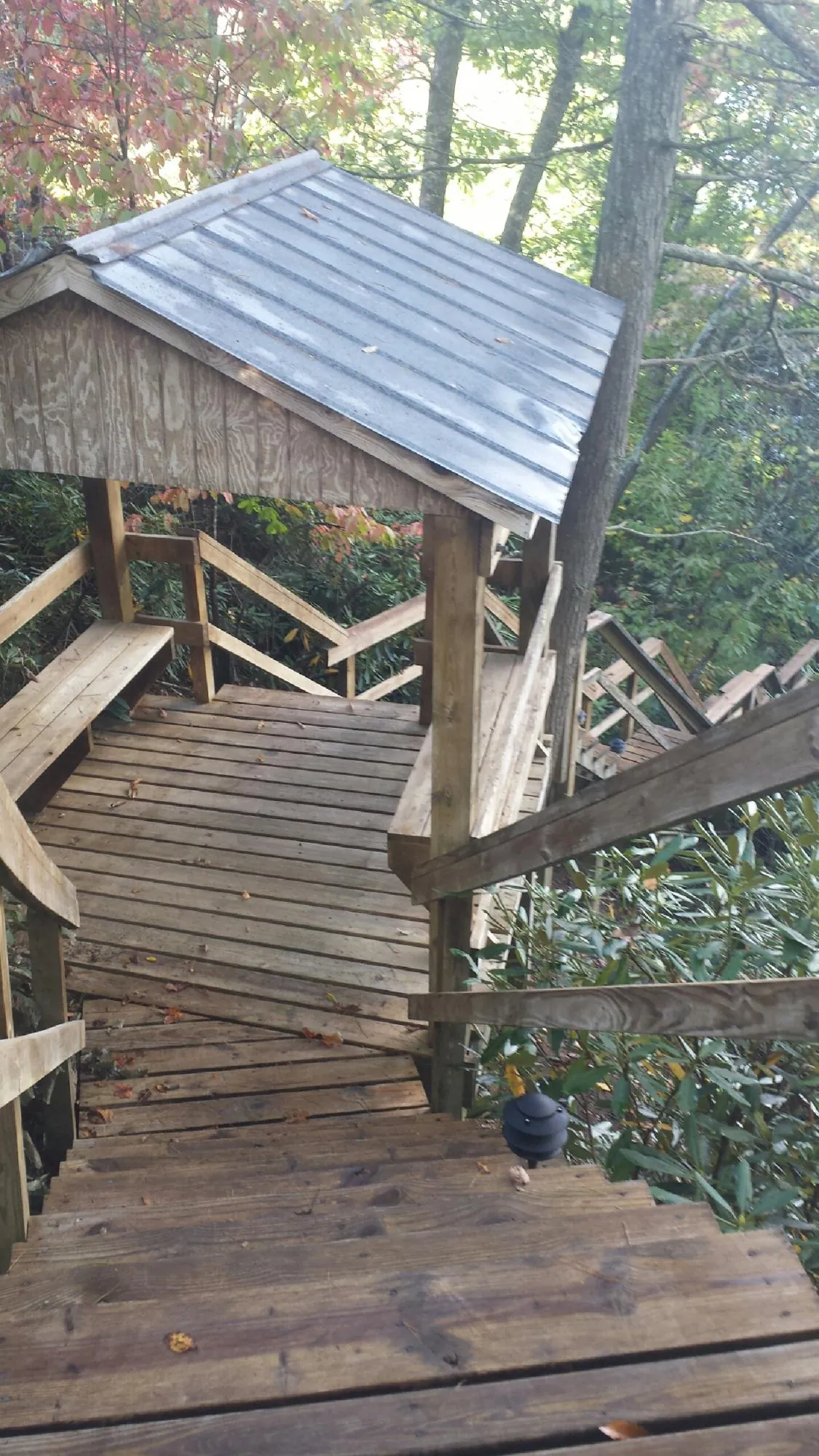 Metal roofed shelter over wooden steps on a wooded walkway — Skylight Repair & Installation work by our crew in Summersville